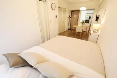 a bedroom with a white bed and a dining room at Vermidor Ebisu302 in Tokyo