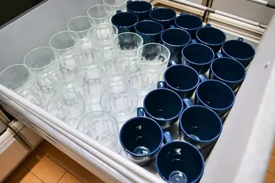 a white drawer filled with blue and white glasses at KODAKA Hotel TOKYO in Tokyo