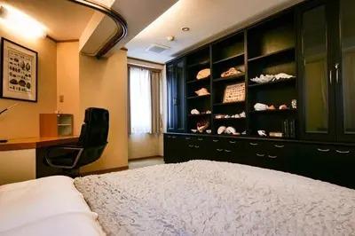 a bedroom with a bed and a desk and a chair at KODAKA Hotel TOKYO in Tokyo