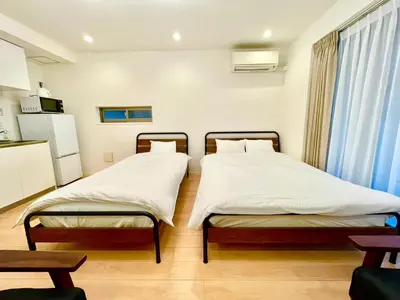 two twin beds in a room with a kitchen at SALON\u6e0b\u8c374B in Tokyo