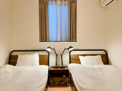 two twin beds in a room with a mirror at SALON\u6e0b\u8c374B in Tokyo