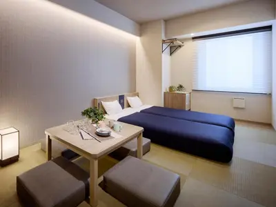 a bedroom with a blue bed and a table at Minn Ueno Shin-Okachimachi in Tokyo
