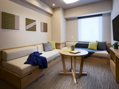 a room with two beds and a table at Minn Ueno Shin-Okachimachi in Tokyo