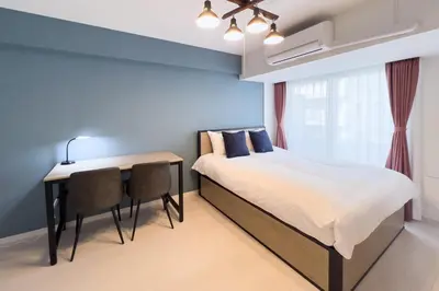 a bedroom with a bed and a desk and a window at Sky Kinshicho in Tokyo