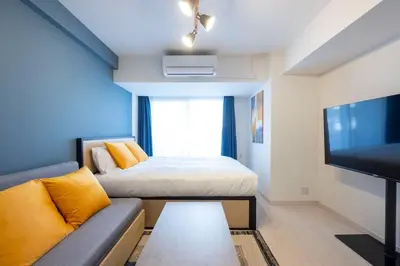 a living room with a bed and a tv at Sky Kinshicho in Tokyo
