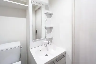 a white bathroom with a sink and a mirror at Sky Kinshicho in Tokyo
