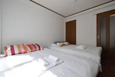 two white beds sitting next to each other in a room at \u30e1\u30be\u30f3\u516b\u5343\u4ee3102 in Tokyo