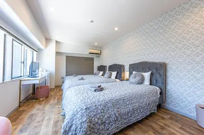 a bedroom with two beds and a television in it at Inn The Omotesando in Tokyo