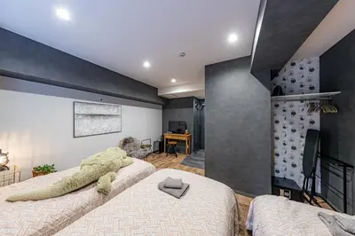 a bedroom with two beds and a tv in it at Inn The Omotesando in Tokyo