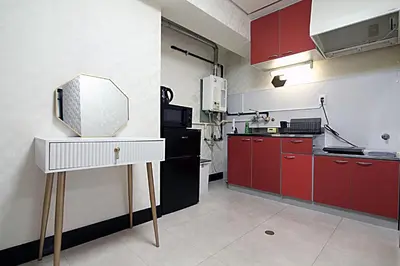 a kitchen with red cabinets and a white counter top at Shinjuku! Hayashi House 3P Free Wi-fi! in Tokyo