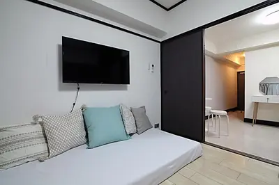 a bedroom with a bed with a tv on the wall at Shinjuku! Hayashi House 3P Free Wi-fi! in Tokyo