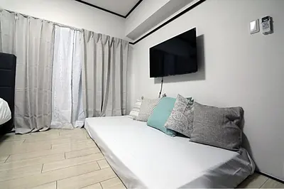 a living room with a couch and a flat screen tv at Shinjuku! Hayashi House 3P Free Wi-fi! in Tokyo
