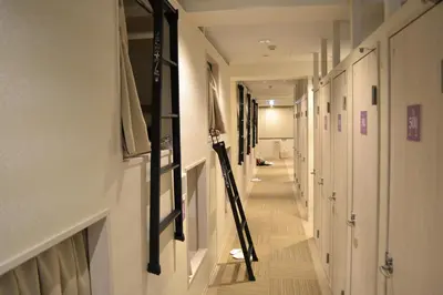 a hallway with white walls and a long hallway with white doors at 1 Night 1980 Hostel Tokyo Asakusa Simple Stay in Tokyo