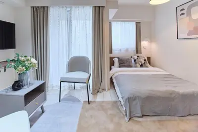 a white bedroom with a bed and a chair at Regnocomfort Asakusa 3 - Vacation STAY 57925v in Tokyo