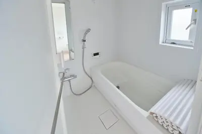 a white bathroom with a tub and a window at Regnocomfort Asakusa 3 - Vacation STAY 57925v in Tokyo