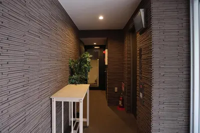 a hallway with a white table and a brick wall at Regnocomfort Asakusa 3 - Vacation STAY 57925v in Tokyo