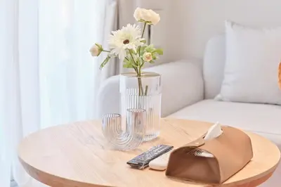 a glass vase with flowers on a wooden table at Regnocomfort Asakusa 3 - Vacation STAY 61882v in Tokyo