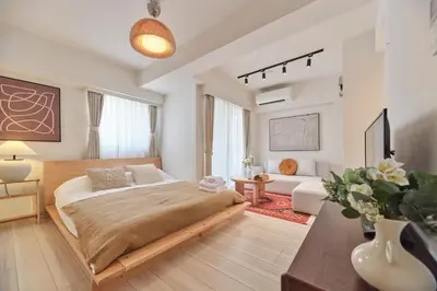 a bedroom with a large bed and a living room at Regnocomfort Asakusa 3 - Vacation STAY 61882v in Tokyo