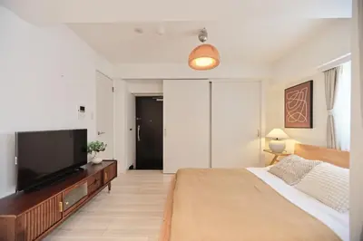 a bedroom with a large bed and a flat screen tv at Regnocomfort Asakusa 3 - Vacation STAY 61882v in Tokyo