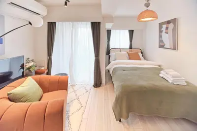 a living room with two beds and a couch at Regnocomfort Asakusa 3 - Vacation STAY 61883v in Tokyo