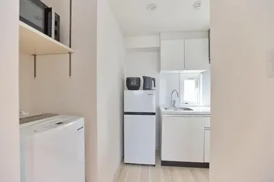 a white kitchen with a refrigerator and a sink at Regnocomfort Asakusa 3 - Vacation STAY 61883v in Tokyo