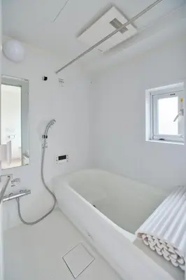 a white bathroom with a bath tub and a window at Regnocomfort Asakusa 3 - Vacation STAY 61883v in Tokyo
