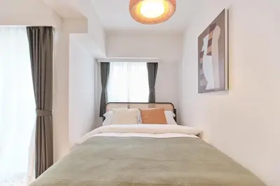 a bedroom with a bed and a large window at Regnocomfort Asakusa 3 - Vacation STAY 61883v in Tokyo