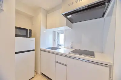 a white kitchen with a sink and a refrigerator at Regnocomfort Asakusa 3 - Vacation STAY 57915v in Tokyo