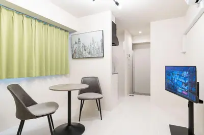 a room with two chairs and a table and a tv at \u30e9\u30a6\u30ec\u30a2\u30bf\u30ef\u30fc\u6c60\u888b in Tokyo