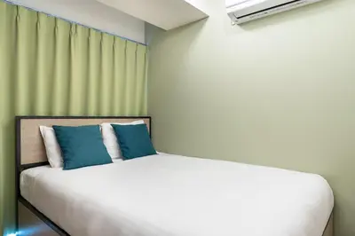 a bedroom with a bed with blue and white pillows at \u30e9\u30a6\u30ec\u30a2\u30bf\u30ef\u30fc\u6c60\u888b in Tokyo
