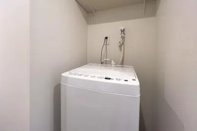 a small kitchen with a sink on top of a refrigerator at toggle BUNKYO KORAKUEN in Tokyo