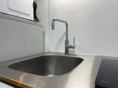a stainless steel sink in a kitchen with a microwave at \u65b0\u5bbf\u30a8\u30ea\u30a2be\u30c6\u30e9\u30b9\u897f\u65b0\u5bbf in Tokyo
