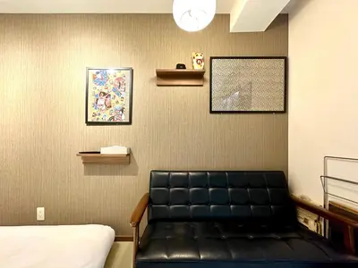 a waiting room with a black leather bench in a room at \u4e0a\u91ce\u6d45\u8349\u9280\u5ea7\u8fd1\u3044 \u5c71\u624b\u7dda\u5fa1\u5f92\u753a\u99c53\u5206 \u30a2\u30e1\u6a2a3\u5206 \u4e0a\u91ce\u99c510\u5206 \u4e0a\u91ce\u5e83\u5c0f\u8def\u99c53\u5206 \u6e6f\u5cf6\u99c52\u5206 2-4\u4eba \u30ec\u30c8\u30ed\u548c\u98a8\u7573\u5bdd\u5ba4 in Tokyo