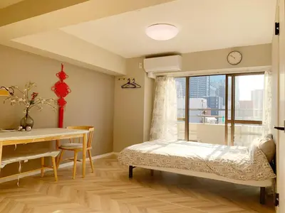 a bedroom with a bed and a table and a window at Shinjuku 2min walk! Shinjuku kabukicho \u6b4c\u821e\u4f0e\u753a! \u8f66\u7ad9\u6b65\u884c2\u5206! 2\u4e2a\u5367\u5ba4\u516c\u5bd3! \u65b0\u88c5\u4fee\u516c\u5bd3!\u5e72\u6e7f\u5206\u79bb! \u667a\u80fd\u9a6c\u6876! \u9ad8\u901f\u65e0\u9650\u5236\u7f51\u8def1001 in Tokyo
