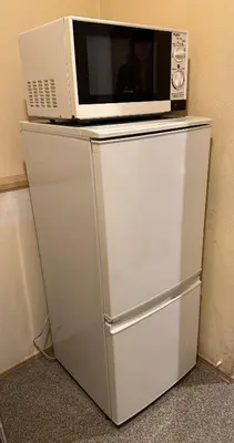 a microwave sitting on top of a refrigerator at Hananosato Hotel \u6c60\u888b\u672c\u5e97 in Tokyo