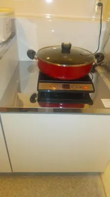 a red pan sitting on top of a stove at Hananosato Hotel \u6c60\u888b\u672c\u5e97 in Tokyo