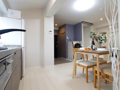 a kitchen with a wooden table and a dining room at \u6e21\u9089\u30d3\u30eb in Tokyo