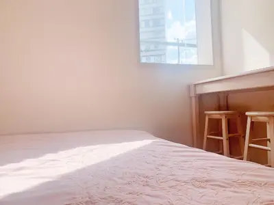 a bedroom with a bed and two stools next to a window at Shinjuku \u65b0\u5bbf\u5f92\u6b65\u5708!\u897f\u65b0\u5bbf!\u90fd\u5385!\u65b0\u5bbf\u4e2d\u592e\u516c\u56ed!2\u5206\u949f\u6b65\u884c\u5230\u5730\u94c1!\u7cbe\u81f4\u516c\u5bd3Autolock!106 in Tokyo