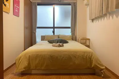 a teddy bear laying on a bed in a bedroom at Compact 2DK in west Shinjuku in Tokyo