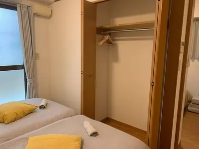 a small bedroom with two beds and a closet at Compact 2DK in west Shinjuku in Tokyo