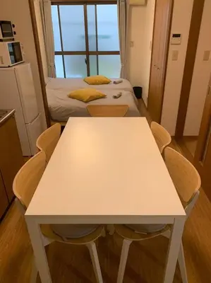 a white table and chairs in a room with two beds at Compact 2DK in west Shinjuku in Tokyo