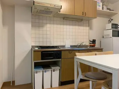 a kitchen with a stove and a white refrigerator at Compact 2DK in west Shinjuku in Tokyo