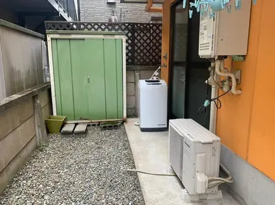 a building with a green door and a heater at Compact 2DK in west Shinjuku in Tokyo