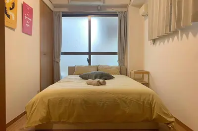 a teddy bear laying on a bed in a bedroom at Compact 2DK in west Shinjuku in Tokyo