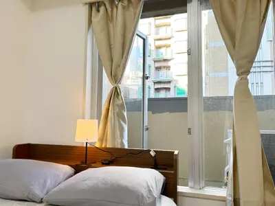 two beds in a room with a window and a lamp at Shinjuku Center\u65b0\u5bbf\u4e2d\u5fc3! 3min walk from subway\u6700\u8fd1\u5730\u94c1\u7ad93\u5206! Shinjuku Kabukicho\u65b0\u5bbf\u6b4c\u821e\u4f0e! \u8457\u540d\u8fde\u9501\u5927\u578b\u516c\u5bd3!314 in Tokyo