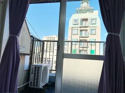 a view of a building from a balcony with curtains at Central Shinjuku/Shinjukukicho/JR Shinuku Station 3 min' walk/新宿中心 新宿歌舞伎/912 in Tokyo