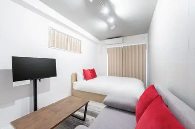 a bedroom with a bed and a tv and a couch at Felice\u68ee\u4e0b in Tokyo