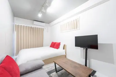 a bedroom with a bed and a flat screen tv at Felice\u68ee\u4e0b in Tokyo
