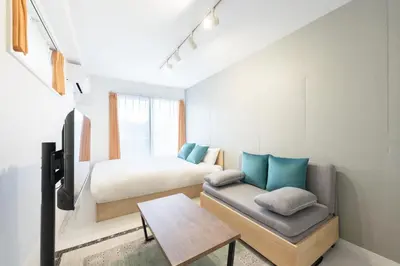a bedroom with a bed and a couch and a table at Felice\u68ee\u4e0b in Tokyo