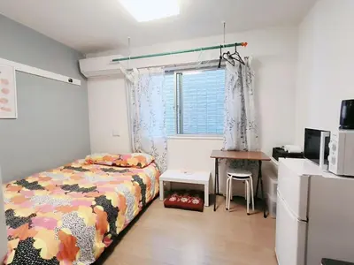 a bedroom with a bed and a table and a window at JR t akadababa subway 5 mins walk! Newly building \u65b0\u7bc9! \u9ad8\u7530\u99ac\u5834\u99c5 \u5f92\u6b69\u570f\u5185\u5927\u4eba\u6c17! Shinjuku\u65b0\u5bbf\u5708!\u9ad8\u901f\u65e0\u9650\u5236Wi-FI! B2 in Tokyo